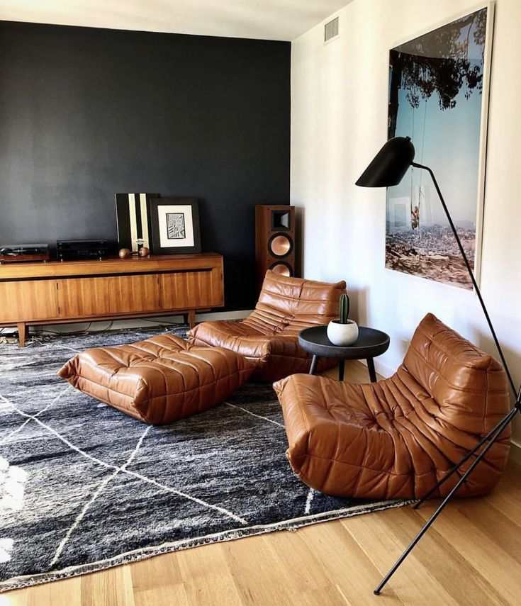 modern brown leather armchair and ottoman set in stylish living room with floor lamp and wooden sideboard